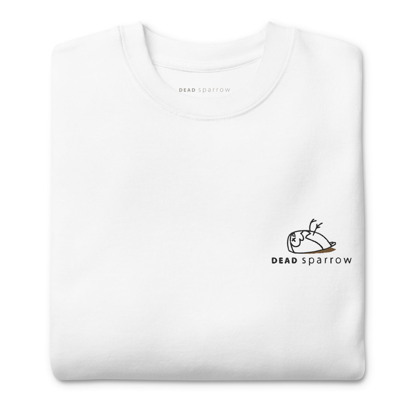 Close-up of a folded organic sweatshirt in the color white. The Deadsparrow logo embroidered on the left side of the sweatshirt with black and gold thread. Product name Creative.
