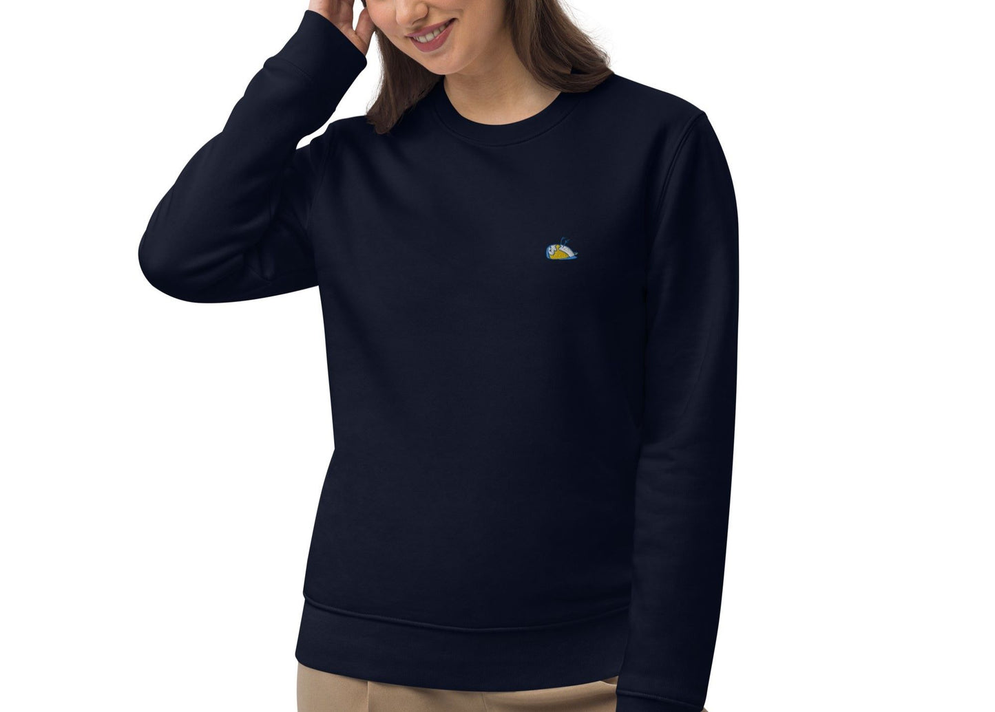 Close-up of a woman displaying a french navy sweater, Thoughtful. The sweater has a multi-coloured sparrow embroidered on the left side of the t-shirt.