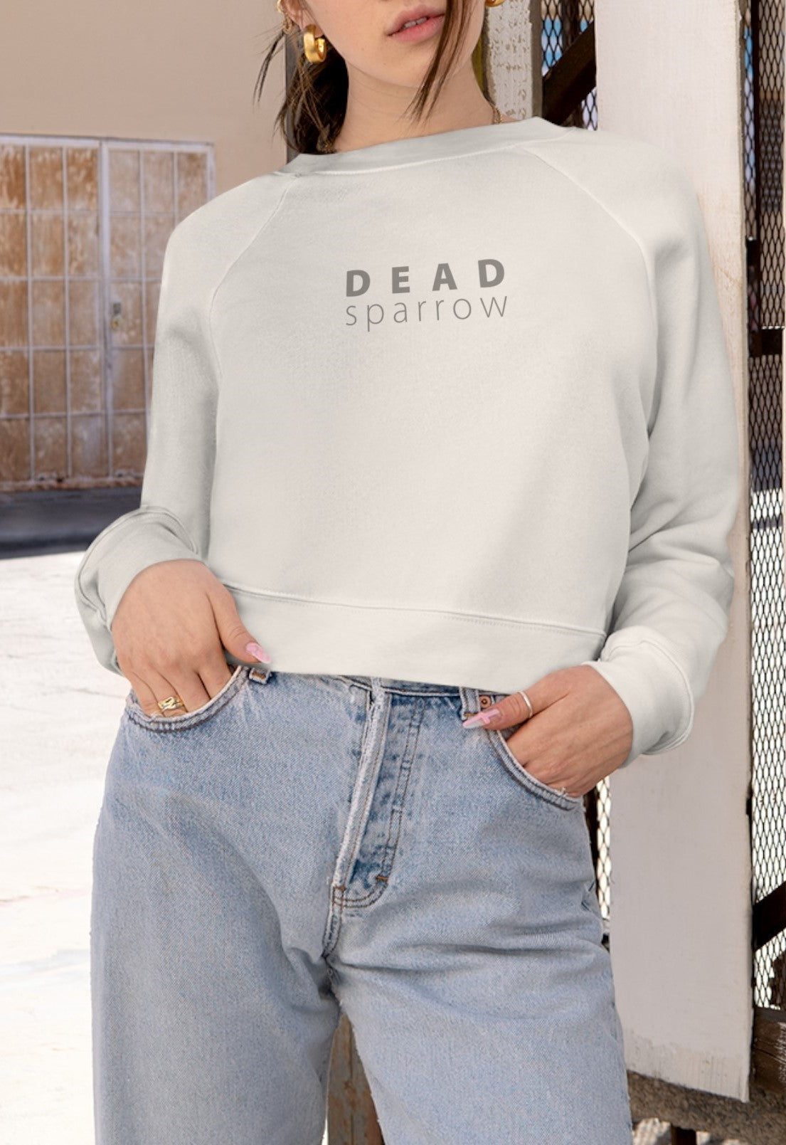 Front view of a woman wearing a navy blue sweatshirt. "Deadsparrow" printed on the front. Product name Abundant.