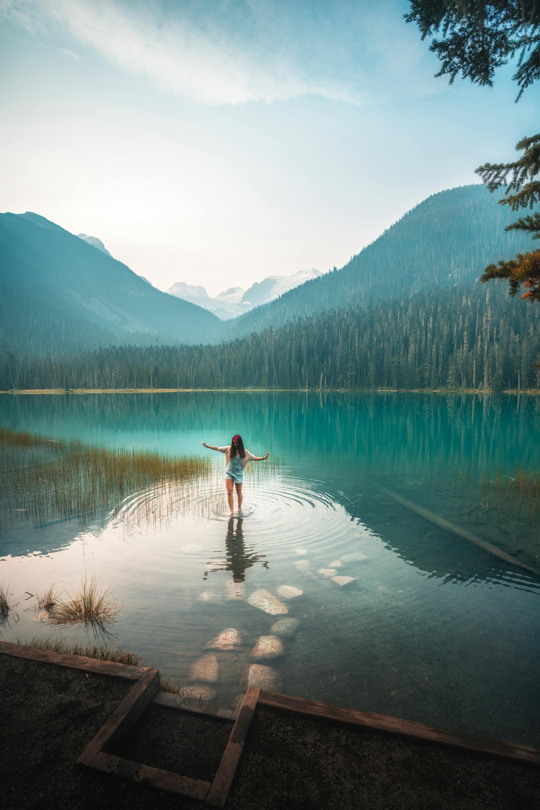 Image of a woman dipping her feet in the sea. Scenic image.