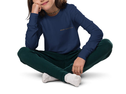 Image of a girl in a long-sleeved t-shirt with the DEADsparrow logo printed on the left side. The colour of the long-sleeved t-shirt is navy blue with a gold print. Product name Skilled.