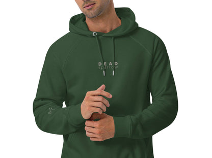 Close-up of a man wearing a green hoodie, item name Peaceful. The hoodie has a print centred on the DEAD sparrow (logo).