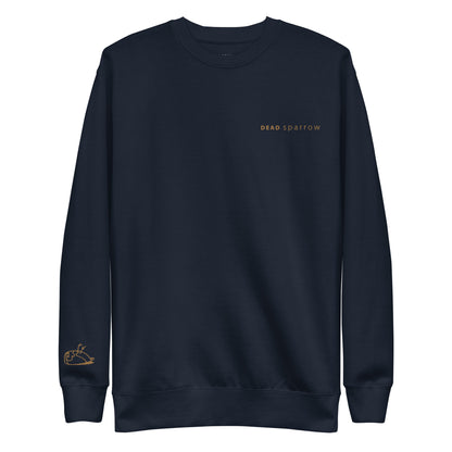 Close-up of an organic sweatshirt for men. The colour of the sweatshirt is navy. Embroidery on the left side of the sweatshirt with the text DEADsparrow and on the right sleeve a sparrow, all in gold thread. Product name Enough.