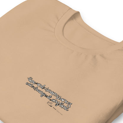 Image of an eco-friendly Desert Dust t-shirt for men. In the image, the t-shirt is folded and has a quote printed on the left side. The quote reads "time and circumstances can change at any time". The product name Strong.