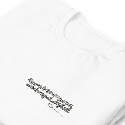 Close-up of an eco-friendly white t-shirt for men. In the image, the t-shirt is folded and has a quote printed on the left side. The quote reads "time and circumstances can change at any time". The product name Strong.