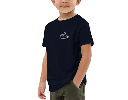 Image of a little boy wearing an eco-friendly French navy blue t-shirt. Print of a sparrow on the left side of the t-shirt. The print is white in colour. Product name Precious.