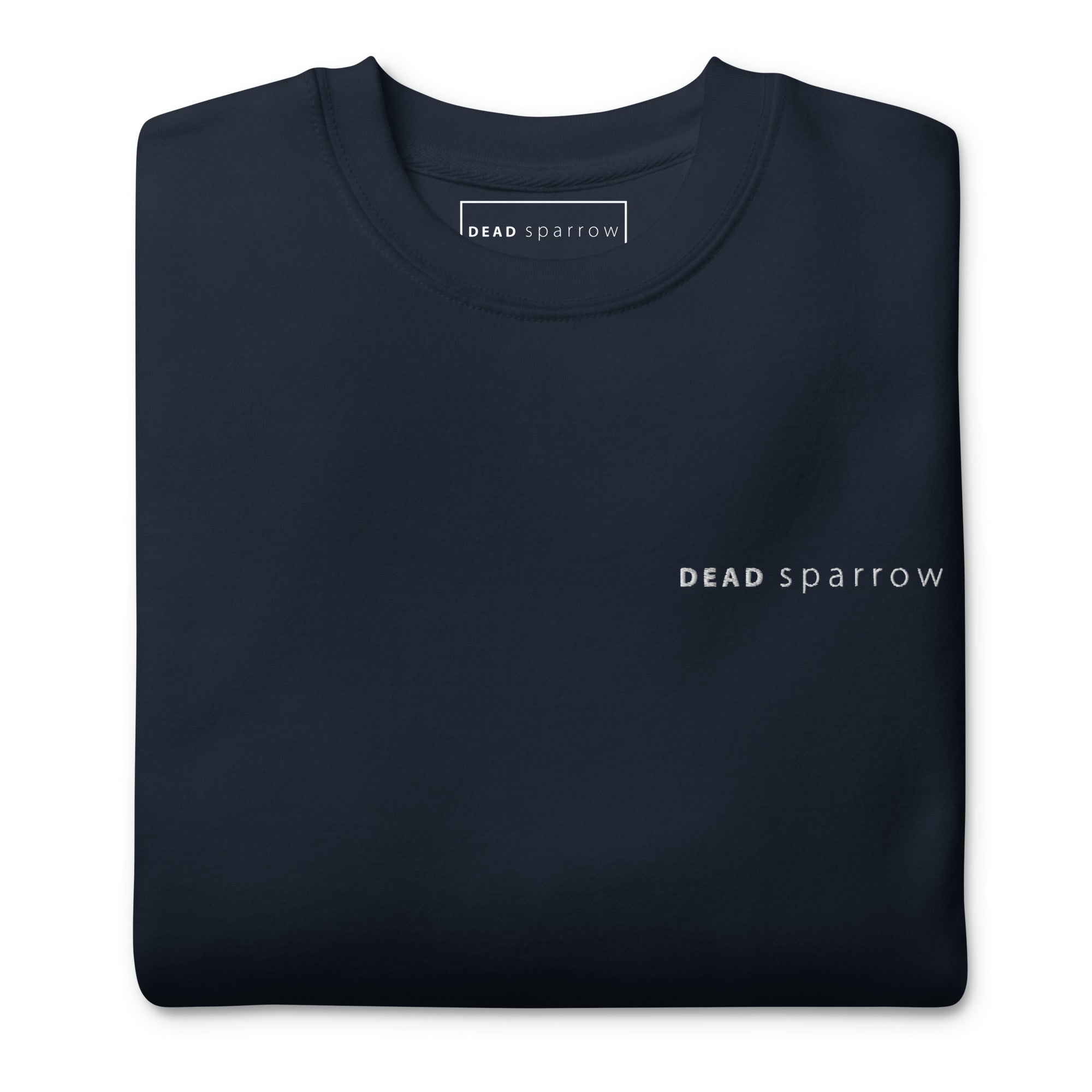 Close-up of a folded navy blue sweatshirt. The text "Deadsparrow" embroidered on the left side of the sweatshirt in white thread. Product name Brave.