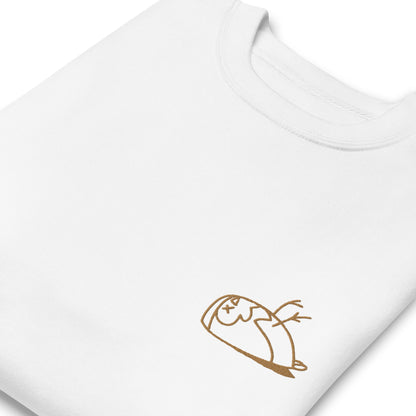 Close-up of a DEADsparrow sweatshirt for children. The sweatshirt is white, soft and folded. The sparrow is embroidered on the left side of the sweatshirt with gold coloured thread. Product name Valuable.