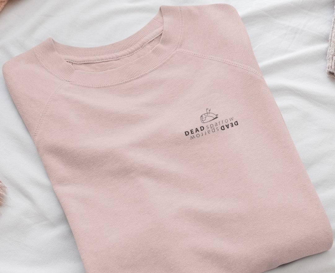 Image of a folded  sweatshirt,Bubbly. The colour of the sweatshirt is cream heather pink.