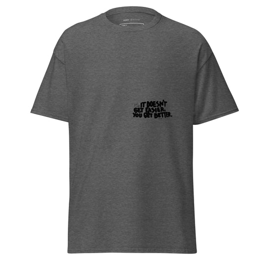 Image of a t-shirt for men. The color of the t-shirt is dark heather. on the left side of the t-shirt, there is a quote that reads "dosen`t get easier you get better". The product name of the t-shirt is Admirable. 