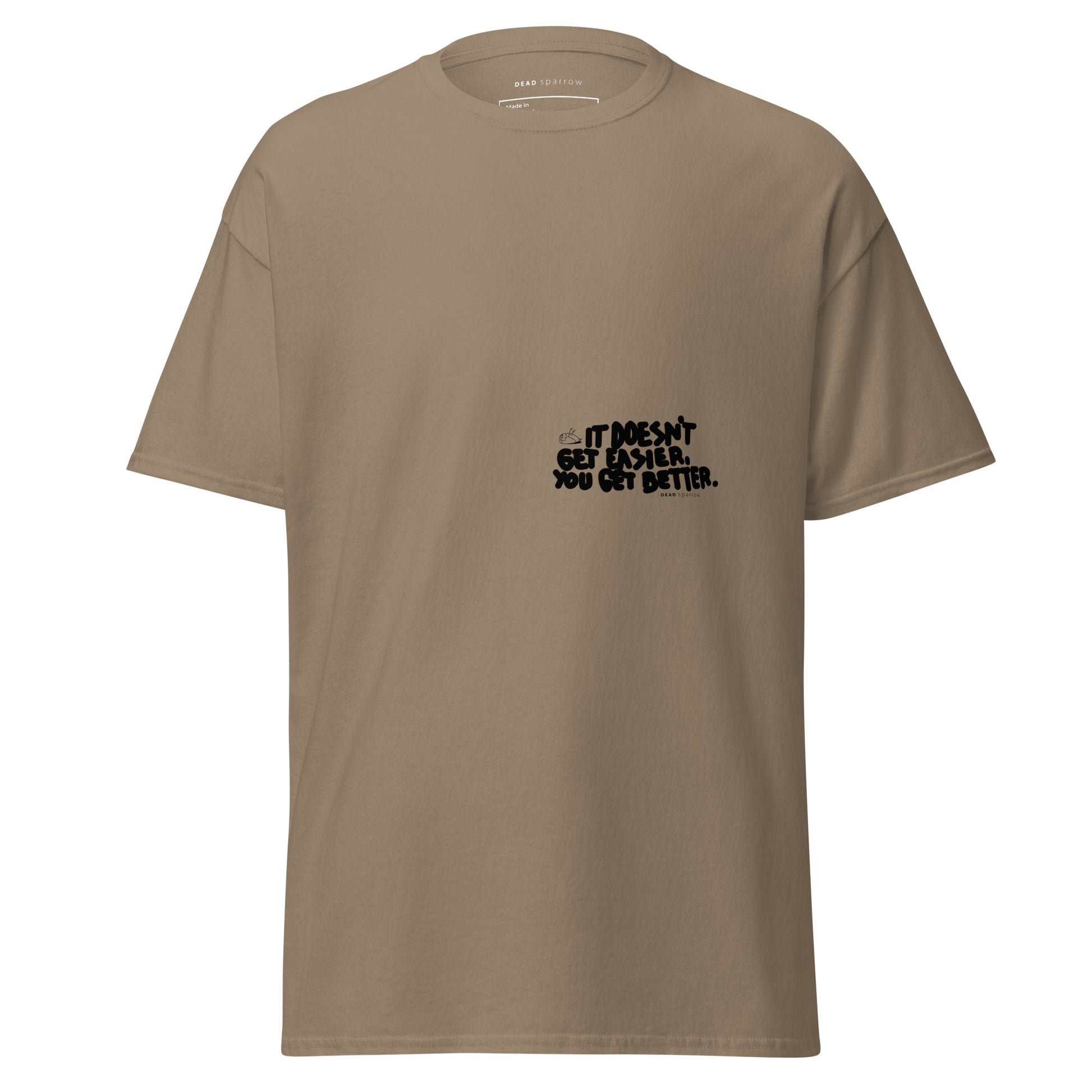 Image of a t-shirt for men. The color of the t-shirt is brown savana. On the left side of the t-shirt, there is a quote that reads "dosen`t get easier you get better". The product name of the t-shirt is Admirable. 