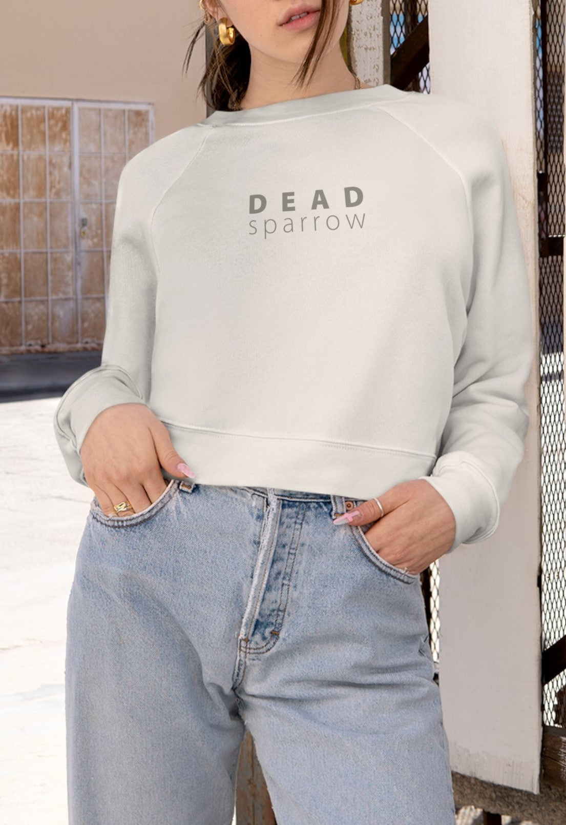 Front view of a woman wearing a navy blue sweatshirt.  "Deadsparrow" printed on the front. Product name Abundant.