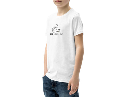 Image of a boy wearing a white t-shirt printed with the DEAD sparrow logo. The logo has a black outline and a beige shadow. Product name Kind.